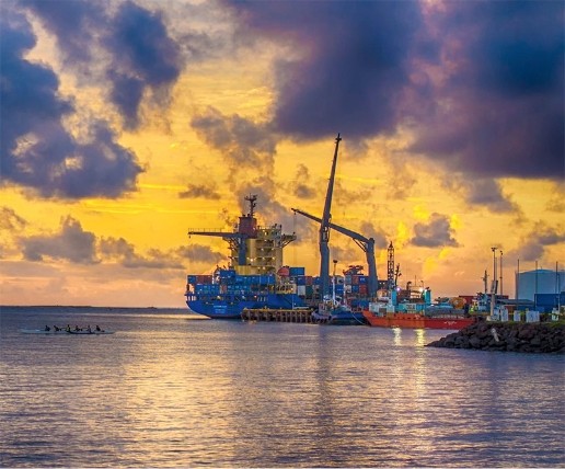 Dock with container ships, sunsetting in background